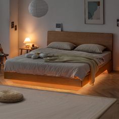 a bed with two towels on top of it in a bedroom next to a lamp