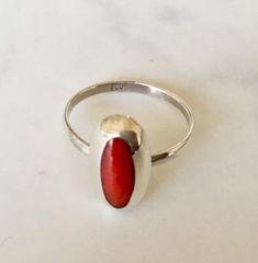 925 sterling silver & red coral ring   Red Coral cabochon gemstone bezel set in sterling silver Highest quality 925 sterling silver (92.5% pure silver) & red coral Large oval red coral gemstone No two pieces of natural stone are identical. Colour variations and markings in the natural stones makes this a truly unique piece Perfect for stacking or minimalist wear Specifications:     Color: Silver & Red  Material: 925 Sterling Silver & Red Coral Dimensions of gemstone: 14 mm x 4 mm approximately D Coral Ring, Red Band, Red Coral, Jewelry Pouch, Solitaire Ring, Pure Silver, Rings Statement, Statement Rings, Coral