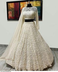 a white wedding gown on display in front of a painting