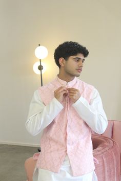 Meet Shehzaan! This is a complete 3-piece mens set perfect for any Indian event you need to attend. Features a blush pink vest on georgette base with floral and machine embroidery. Paired with a white kurta set. Looks good on its own or paired with any vest in your closet. Kurta, vest, and pants included. Formal Pink Kurta With Naqshi Detailing, Designer Pink Kurta With Resham Embroidery, Pink Sherwani For Spring Festivals, Spring Wedding Nehru Jacket With Dabka, Spring Wedding Pink Nehru Jacket, Elegant Pink Nehru Jacket For Festive Occasions, Festive Pink Designer Bandhgala, Pink Fitted Set With Naqshi Detailing, Fitted Bollywood Style Pink Nehru Jacket