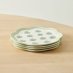 four green and white plates stacked on top of each other