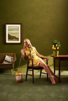 a woman sitting in a chair with a jar of honey on the floor next to her