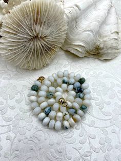 "Have you ever wanted a piece of jewelry that will stand out and make a statement? Look no further than this beautiful Hand Knotted Mixes White Peruvian Opal Necklace! Made with genuine Peruvian opals, this necklace features gold end caps made of plated brass, and each necklace is unique as the natural opals used are one-of-a-kind. The beads are rondelle shaped and measure approximately 8mm x 5mm, and the necklace is 17-18\" long. Plus, orders placed by 11:00 am EST Monday-Friday ship the same day or next business day, making it perfect for those last minute gifts. And, with lead and nickel safe construction, you can rest assured that this necklace is safe to wear.  FEATURES:  💎 Genuine Peruvian Opals: Each necklace is unique due to the natural opals used.  💍 Gold End Caps: Made of plate White Rondelle Necklace With Spacer Beads, White Rondelle Spacer Bead Necklaces, Oval Hand-strung Beaded Necklace For Gift, White Oval Single Strand Necklace, Oval Hand-strung Beaded Necklaces As Gifts, White Oval Gemstone Beads Necklaces, White Hand-strung Rondelle Necklace, White Hand-strung Round Necklaces, Hand Knotted Pearls