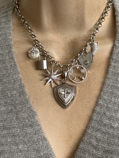 This statement necklace features seven charms: stainless steel bee shield in center, rodium plated CZ protection Talisman charm, mother of pearl CZ heart, CZ horn, stainless steel padlock, Northstar and button pearl CZ clover. These charms hang on a stainless steel sturdy non tarnish chain. Adjustable length including the extension is approximately 17-19 inches. Stainless steel lobster clasp. 🎁All orders are shipped in a box. Gift messages are attached to the box. Silver Heart Necklace With Removable Charms, Silver Sterling Charm Necklace With Removable Charms, Silver Jewelry With Removable Heart Pendant Charms, Silver Sterling Charm Necklace With Detachable Pendant, Silver Charm Necklace With Detachable Pendant, Silver Pendant Charm Necklace With Removable Charms, Elegant Silver Vintage Charms, Silver Heart Pendant Locket Necklace With Vintage Charm, Silver Charm Necklace With Detachable Pendant As Gift