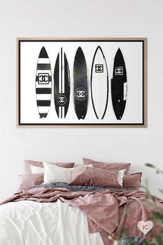 three surfboards mounted on the wall above a bed