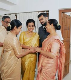 three women and one man are standing together