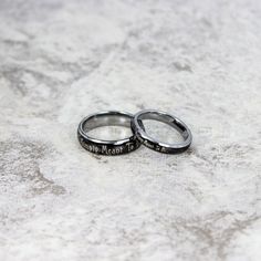 two wedding rings with words engraved on them