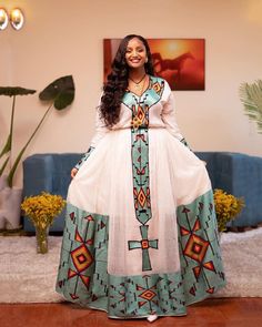 This breathtaking Habesha dress is made of luxurious Menen fabric in a deep shade of green, with a Tibeb bottom that adds a touch of traditional elegance. The Tibeb is a type of Ethiopian embroidery that features intricate geometric patterns and vibrant colors, and it is typically used to decorate the bottom part of the dress. The dress also features an intricate Tilf design that adds a touch of sparkle and glamour to the garment. The Tilf design is featured prominently on the bodice and sleeves Ethiopian Embroidery, Eritrean Dress, Ethiopian Clothing, Habesha Dress, Ethiopian Traditional Dress, Ethiopian Jewelry, Habesha Kemis, Flowing Skirt, Baby Outfit