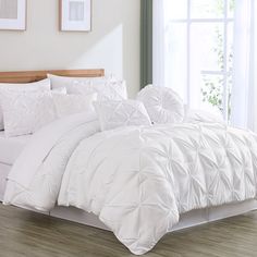 a white comforter and pillows in a bedroom