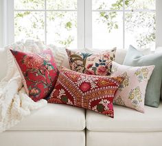 a white couch topped with lots of pillows