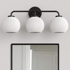 a bathroom vanity with three lights and a mirror