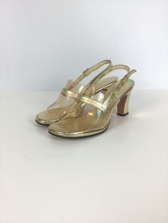 "Highly recommend getting a good pedicure for these sassy vintage 1960s gold lame leather peep toe high heels Made of gold lame leather clear plastic toebox that is highlighted with a gold strap.  Gold instep The heel of the shoe is also covered in gold-colored leather Adjustable slingback strap for a secure fit, gold toned metal buckle  Soles of the shoes are made of leather Open-toe peep-toe style Measurements: Marked size 5M US 5 US/ 34.5 EU/ 21 Asia Insole: 8 5/8\" Ball: 2.75\"  Heel height: Gold Almond Toe Slingback Pumps For Formal Occasions, Gold Almond Toe Slingback Pumps For Formal Events, Vintage Gold Heels For Summer, Retro Pointed Toe Party Sandals, Gold High Heel Slingback Sandals For Evening, Retro Pointed Toe Sandals For Party, Gold Slingback Sandals For Party, Gold Slingback Sandals With Round Toe For Party, Gold Slingback Sandals For Party With Open Heel