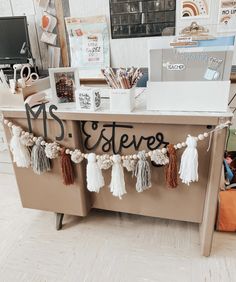 an office desk decorated with tassels and letters that spell out the word estate