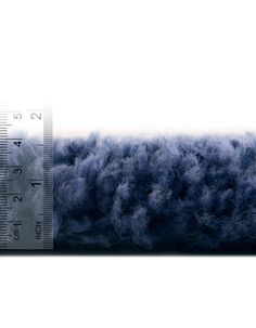 a large ruler with blue and white fur on it's side, measuring the length