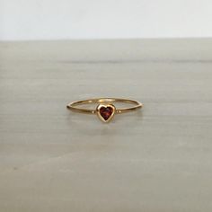 This Garnet Heart Ring brings love with you wherever you go. Show someone you love that you always have them in your heart. A great gift ring! Details: 14k gold (available in yellow, rose or white gold)Garnet heart measures about 3mm Free Shipping on Domestic Orders Materials: Garnet, 14k gold Need your ring bigger than whats offered? An additional fee will be applied to ring orders larger than size 8. Please contact us for exact pricing or feel free to place your order and we will send you an a