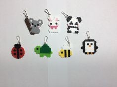 six keychains made out of different types of animals and insects on white paper