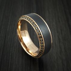 a black and gold wedding ring with diamonds