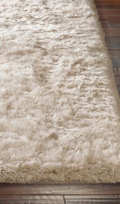 a white rug on top of a wooden floor