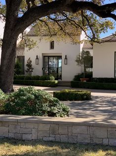 a large white house sitting next to a tree