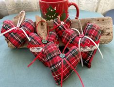 red and black plaid heart shaped ornaments next to a coffee mug