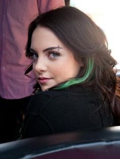 a woman with green hair sitting in a car