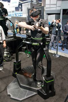 a man standing on top of a chair with a vr headset in his hand