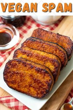 grilled vegan spam on a white plate with spoons next to it