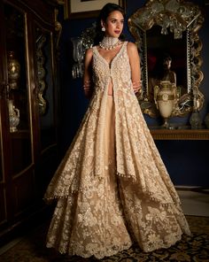 This high-low sharara set features intricate pearl, sequins and crystal embroidery. The nude jacket shows a plunging neckline with bead and crystal detail. The heavily embroidered dupatta shows scalloped on all four sides with pearl and crystal tassels. DELIVERY TIMEPlease allow 8-12 weeks for your outfit to arrive. FABRIC DETAILSSharara - Net / Dupatta - Net Professional cleaning only. Indian Net Dresses, Traditional Outfits Indian Wedding, Bridal Sharara Indian, Indian Destination Wedding Outfits, Indian Reception Lehenga, Long Jacket Outfit Indian, Outfit For Wedding Reception, Sharara With Jacket, Indian Reception Dress