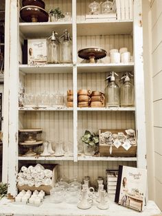 an old china cabinet filled with glassware and other items in it's display case