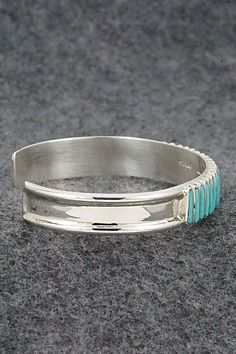 This turquoise and sterling silver bracelet was made by Zuni silversmith Lucy Sheyka. The back is signed LS, Zuni and stamped sterling.Size: 5 1/4" (will fit up to a 6 1/4" wrist)Gap: 1"Width: 3/8"Free shipping on all orders! We ship with USPS and always include tracking. All orders ship within a day of payment.Returns are accepted up to 30 days after you receive your order. Just send us a message. Our shop offers cash back or store credit. The item must be returned in new condition. Artisan Turquoise Sterling Silver Bracelet, Adjustable Turquoise Sterling Silver Artisan Bracelet, Artisan Turquoise Cuff Bracelet In Sterling Silver, Turquoise Stamped Sterling Silver Cuff Bracelet, Round Turquoise Sterling Silver Cuff Bracelet, Adjustable Turquoise Sterling Silver Bracelet, Unique Turquoise Sterling Silver Bracelets, Adjustable Turquoise Bracelet With Inlay, Adjustable Turquoise Inlay Bracelets