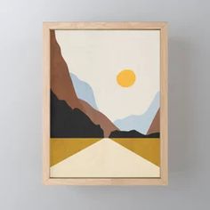 a painting hanging on the wall above a wooden frame with mountains and sun in the background