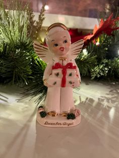 an angel figurine with a red ribbon around it's neck