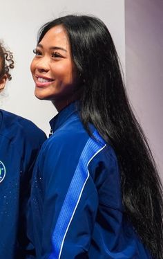 two girls are standing next to each other and one is wearing a blue track suit