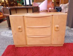 a wooden cabinet sitting on top of a red rug