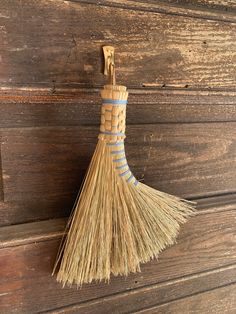 a broom hanging on the side of a wooden wall