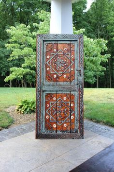 an old wooden door sitting on top of a brick walkway in front of some trees