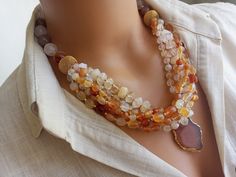 Meet our elegant Quartz - Agate Beaded Necklace, a collection of unique handcrafted jewelry that is sure to attract attention! This eye-catching necklace creates a striking visual with large gem stones in different shades of orange. Perfect as a gift for a beloved mother or wife, this statement chunky multi-strand natural stone summer accessory will add a bohemian touch to any outfit. CARE INSTRUCTIONS: To keep your necklace looking its best, avoid exposing it to harsh chemicals or excessive moi Unique Handcrafted Jewelry, Orange Agate, Jewellery Inspiration, Necklace Chunky, Gem Stones, Crystal Quartz, Summer Accessories, Agate Beads, Agate Gemstone