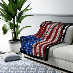 an american flag blanket on a couch next to a potted plant