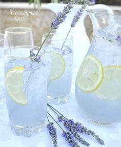 lavender water and lemonade are served in pitchers on a white tablecloth with lavender sprigs