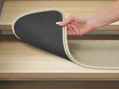 a person's hand on the edge of a carpeted stair tread, pulling it up