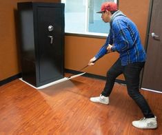 a man with a baseball cap is holding a bat in front of a black box