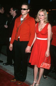 a man and woman standing next to each other on a red carpet at an event