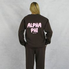 Alpha Phi crewneck sweatshirt is the unisex sorority sweatshirt to start your new school year. This brown, Alpha Phi sweatshirt has trending puff print in pink on the front and back. A new school year means new designs and this unisex, fleece Alpha Phi sweatshirt is part of our new 2024/2025 collection. This cute sorority sweatshirts unisex fit is the ultimate in comfort, warmth and sorority style. Wear this sorority top with everything from jean shorts to jeans, bike shorts to leggings or with the matching sweatpants. Alpha Phi Hoodie Sizing Model is 5'9", size 0/2, and wearing size M A Phi Hoodie Technical Details  - 7.6 oz./yd² (US), 12.7 oz/L yd (CA), 70/30 combed ring-spun cotton/recycled polyester, 31 single  - Reimagined, Recycled, ReFlex Fleece is the next evolution of fleece  - 3- Crew Neck Sweats With Logo Print For College, Relaxed Fit Crew Sweatshirt For Campus, School Spirit Sweatshirt With Lettering For Streetwear, College Logo Print Sweatshirt, School Spirit Sweatshirt For Campus With Relaxed Fit, Varsity Logo Print Sweatshirt For Campus, School Spirit Long Sleeve Sweatshirt With Logo, School Spirit Sweatshirt With Text Print In Relaxed Fit, College Crew Sweats With Letter Print