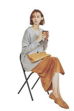 a woman sitting in a chair holding a cup