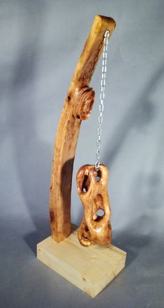 a piece of wood with chains hanging from it's end on a wooden stand