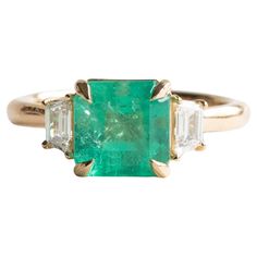 an emerald and diamond ring with three baguets in yellow gold plated silver