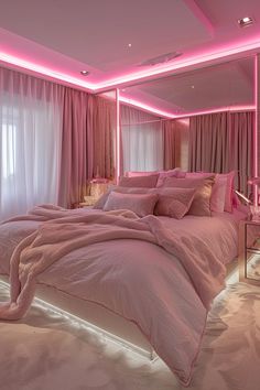 a bed with pink sheets and pillows in a room that is lit up by lights