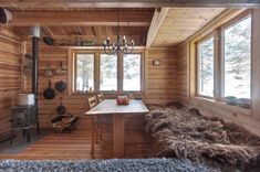 the interior of a cabin with wooden walls and flooring, wood burning stove in the corner