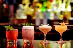 three different types of cocktails sitting on a bar