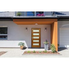 a house with an orange front door and two planters